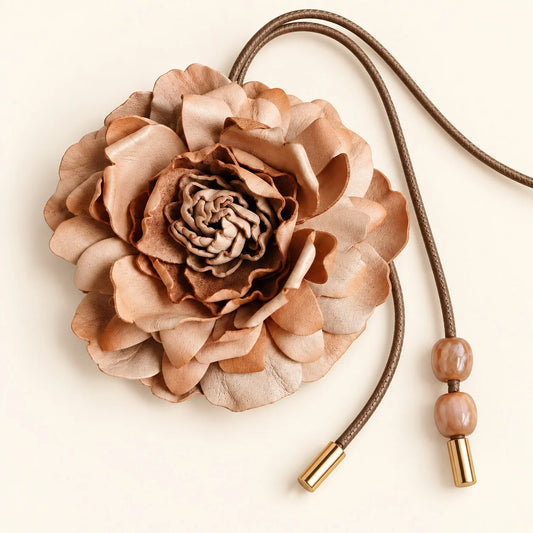 Natural tan sculpted vegetable-tanned leather peony accessory with long brown cord, marbled bead accents and metal-tone tips