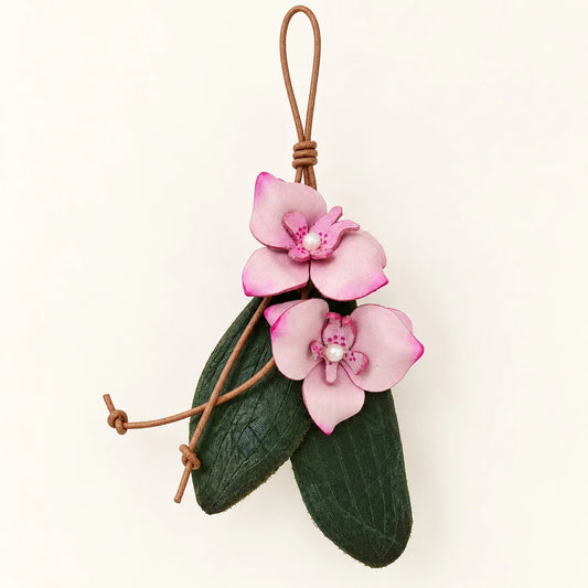 Double pink phalaenopsis leather bag charm with dark green leaves, freshwater pearls and brown leather loop