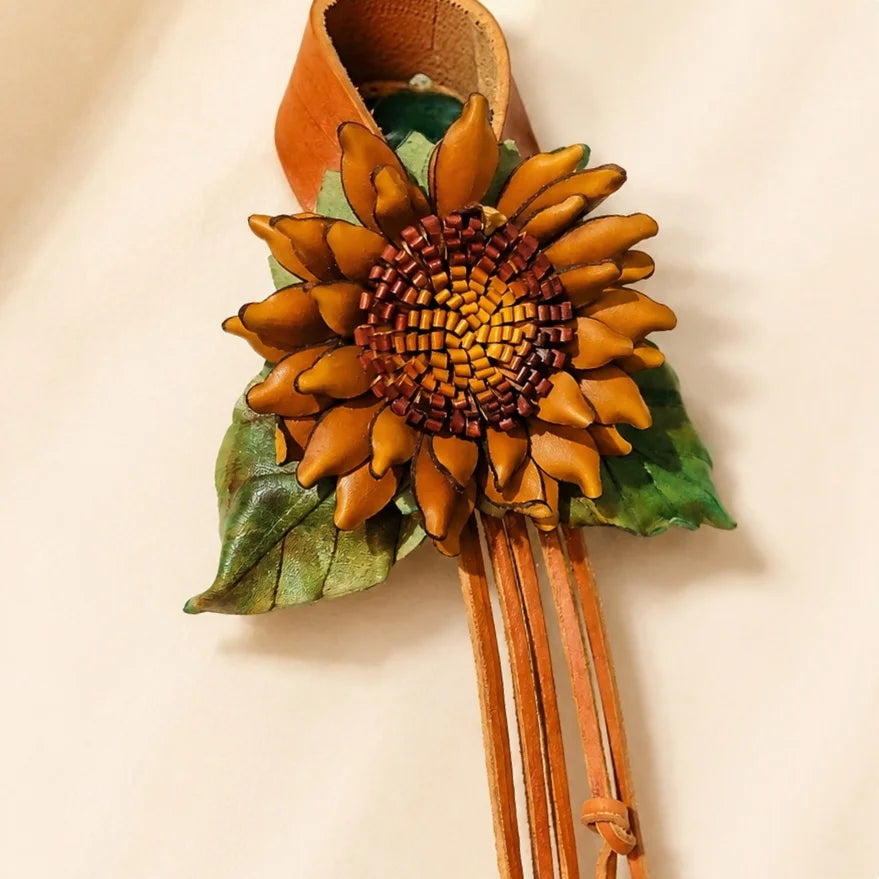 Colgante de cuero hecho a mano con girasol dorado y centro trenzado, correa ancha a presión y borlas largas, accesorio artístico floral para bolso.