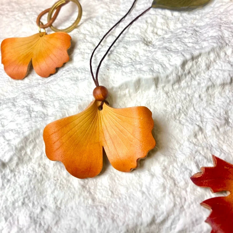 Colgante de cuero Ginkgo Otoñal – Dije artesanal pintado a mano | Accesorio escultórico fluido para bolsos | Regalo elegante para ella