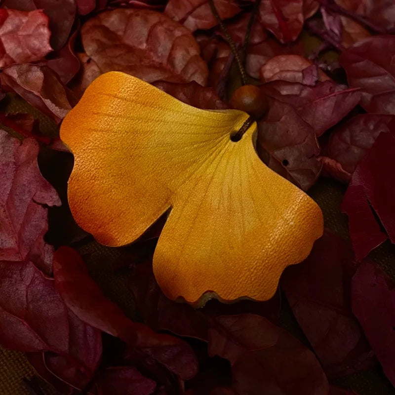 Colgante de cuero Ginkgo Otoñal – Dije artesanal pintado a mano | Accesorio escultórico fluido para bolsos | Regalo elegante para ella