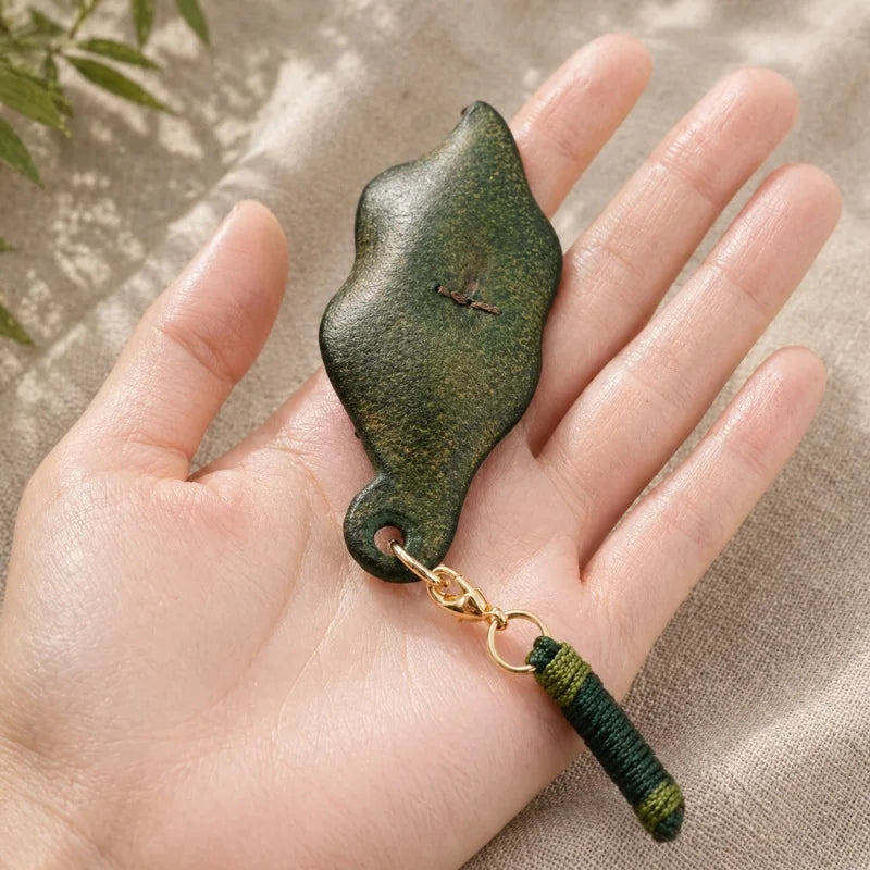 Dije artesanal de hoja de cuero y caracol de bronce para bolso: colgante único inspirado en la naturaleza | Accesorio artístico hecho a mano para bolsos, llaves y regalos