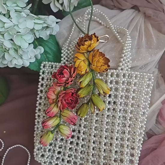 Moonlit Tuberose leather bag charms in yellow and pink, showing sculpted flowers, cascading buds, and hand-held details.